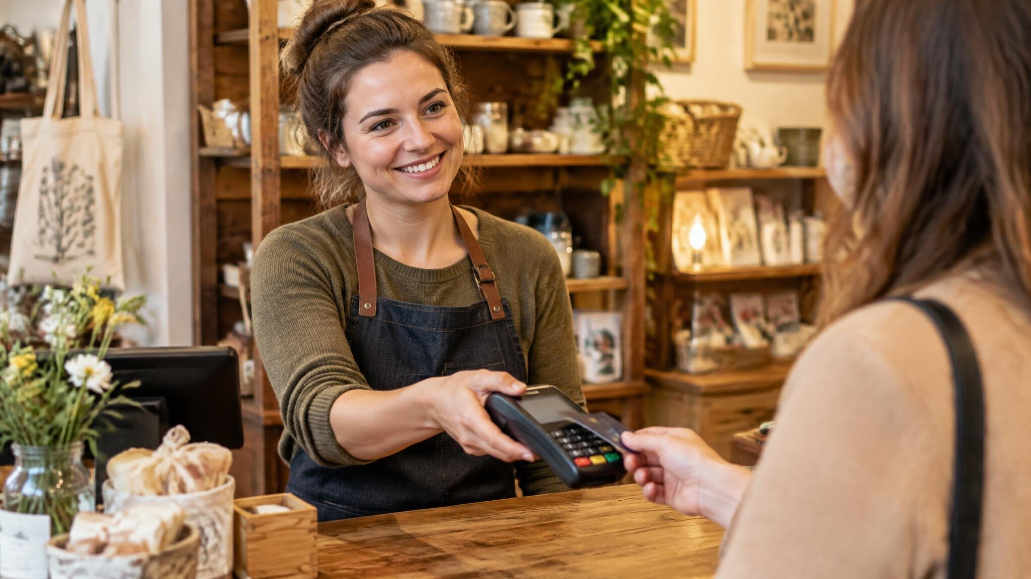 Shop owner welcoming a customer at the checkout counter